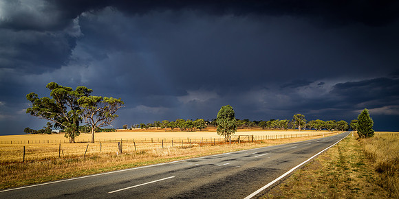 Dark Clouds over a Sundrenched Road